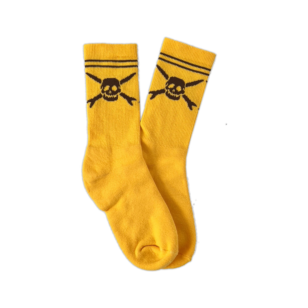 A pair of yellow cotton Teenage Bottlerocket socks with black stripes at the top and a skull and crossbones logo beneath the stripes.