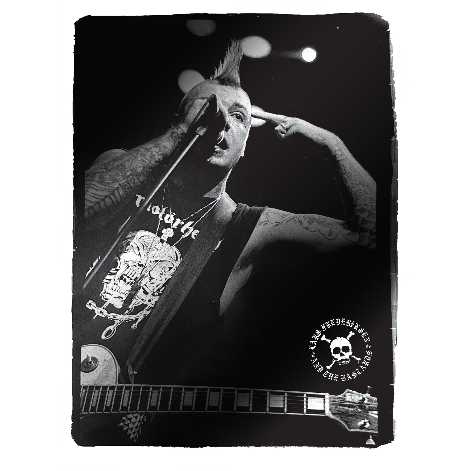 Black-and-white photo of a punk musician with a mohawk, tattoos, and a guitar, singing into a microphone and pointing to his head. A skull logo with text appears in the bottom right corner, reminiscent of the iconic imagery from Lars Frederiksen and The Bastards’ self-titled debut album—now available on colored vinyl.