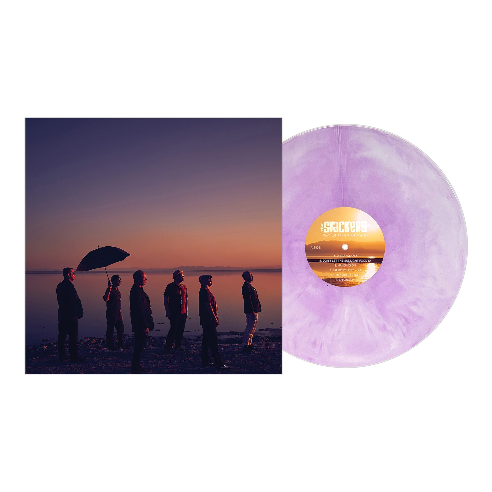 A light purple marbled vinyl record by The Slackers is pictured next to its album cover, which shows the six band members on a beach at sunset—one holding a black umbrella. Released by Pirates Press Records.