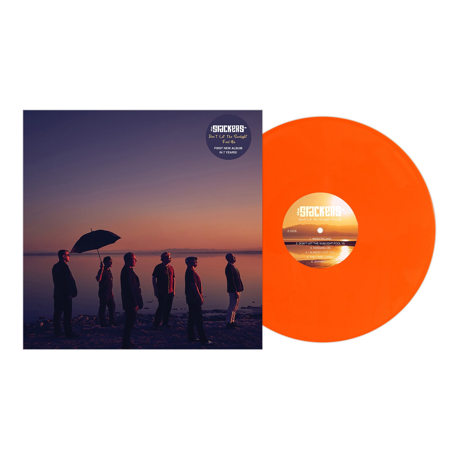 An orange vinyl record by The Slackers rests beside its cover, which shows six people on a sunset shore with purple and orange skies reflected on the water. This album is by The Slackers.