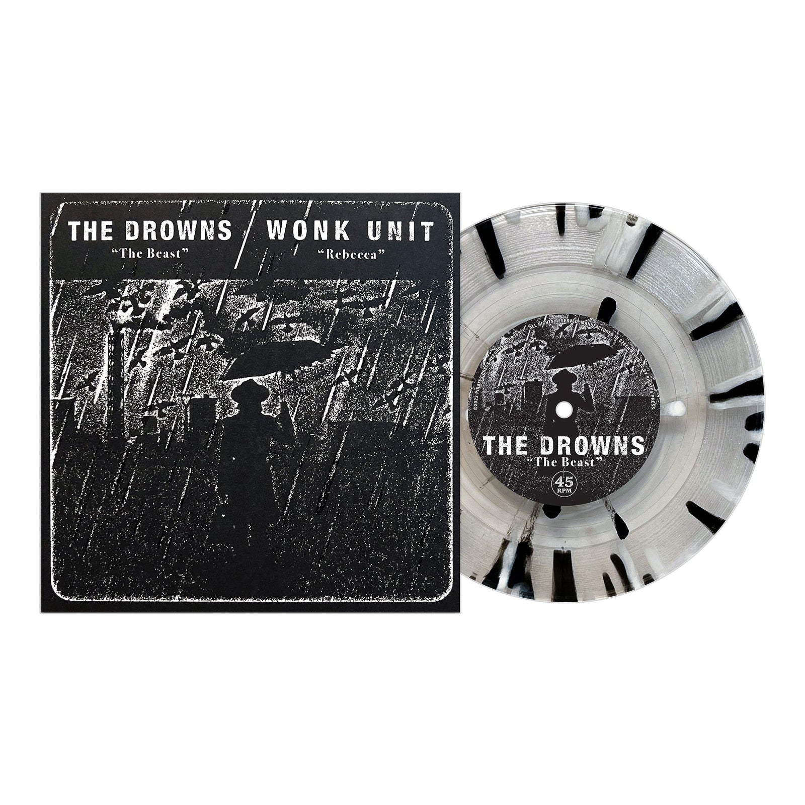 A Pirates Press Records vinyl with black splatter sits beside its cover, showing a silhouetted figure under an umbrella in rain. The cover features punk bands The Drowns and Wonk Unit with songs “The Beast” and “Rebecca.”.