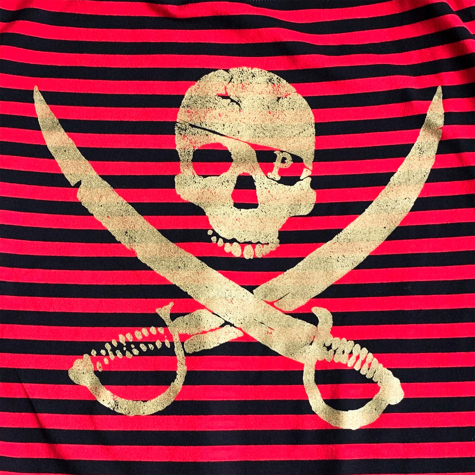 A gold skull above crossed swords is printed on a red and black striped background, creating a pirate-themed shirt from Pirates Press Records.