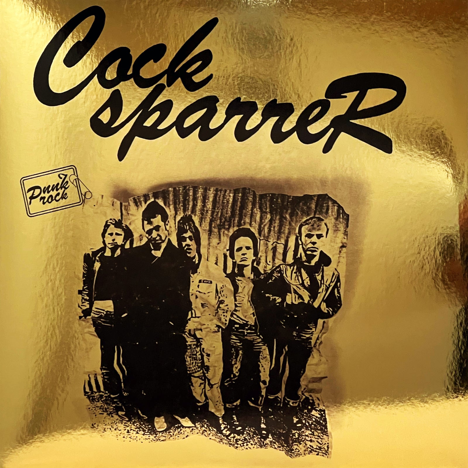 A gold background displays the black Cock Sparrer logo at the top for their 50th anniversary, Punk Rock in a small box on the left, and a black-and-white photo of five men standing side by side.