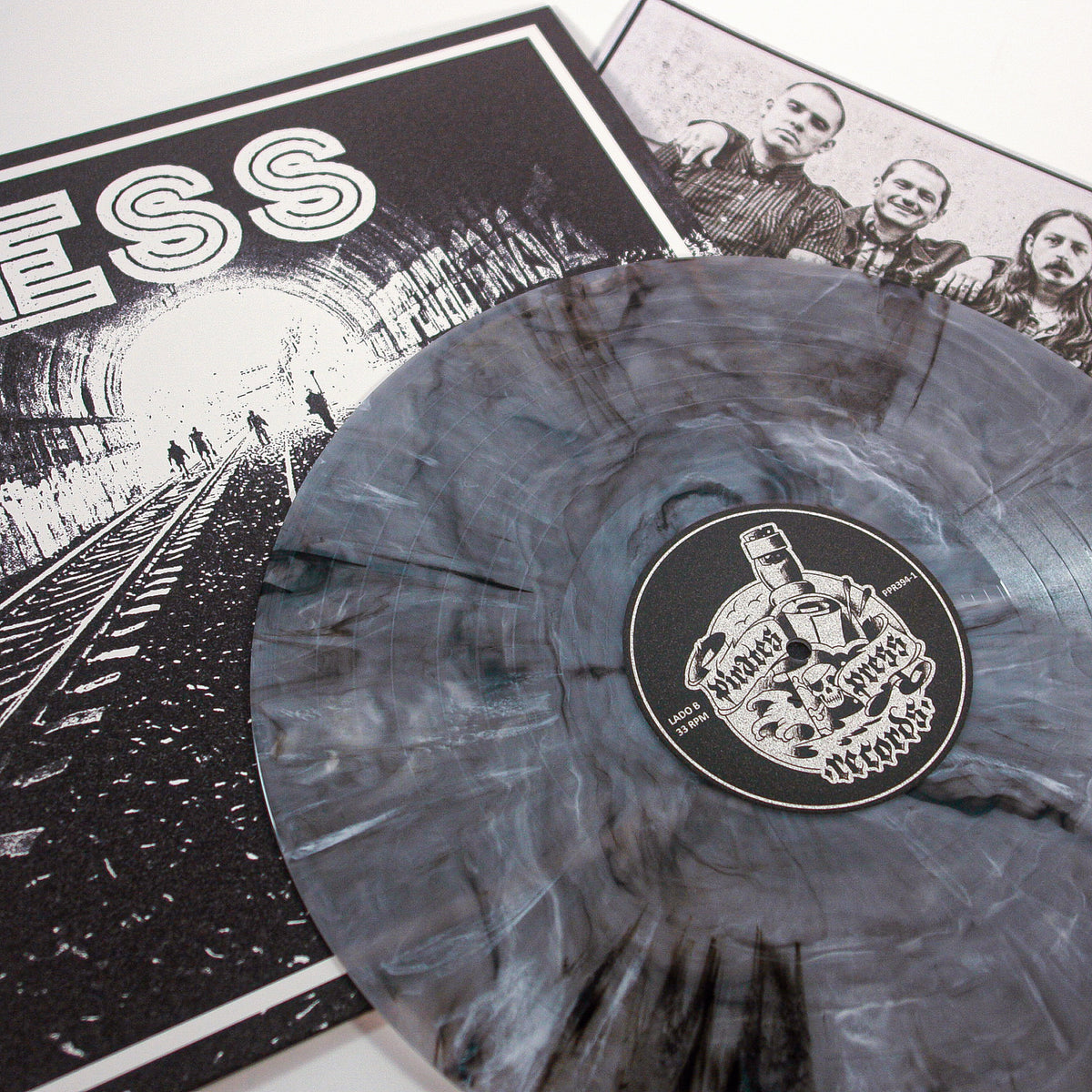 A Ghost Marble Vinyl LP from Mess features a skull-labeled record on a black-and-white cover with a tunnel, train tracks, and silhouettes. A band photo insert peeks out—an ideal collectible for any Mess enthusiast.