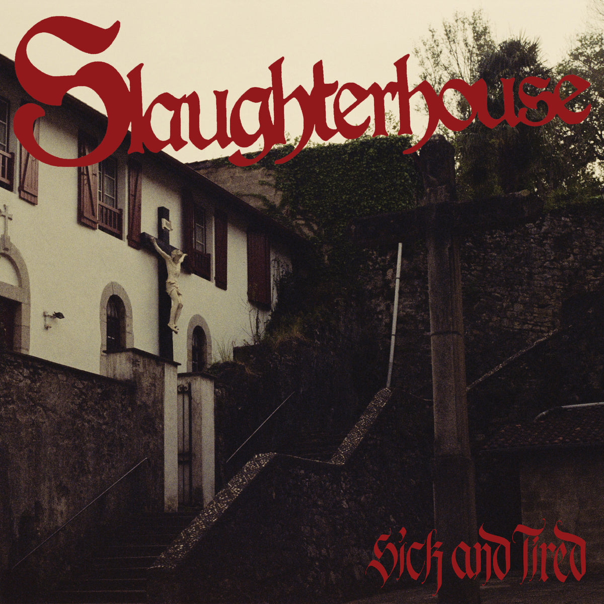 A dimly lit, old building with a crucifix on the wall. The Slaughterhouse brand name and “sick and tired” appear in bold red gothic letters at the top and bottom of the image.