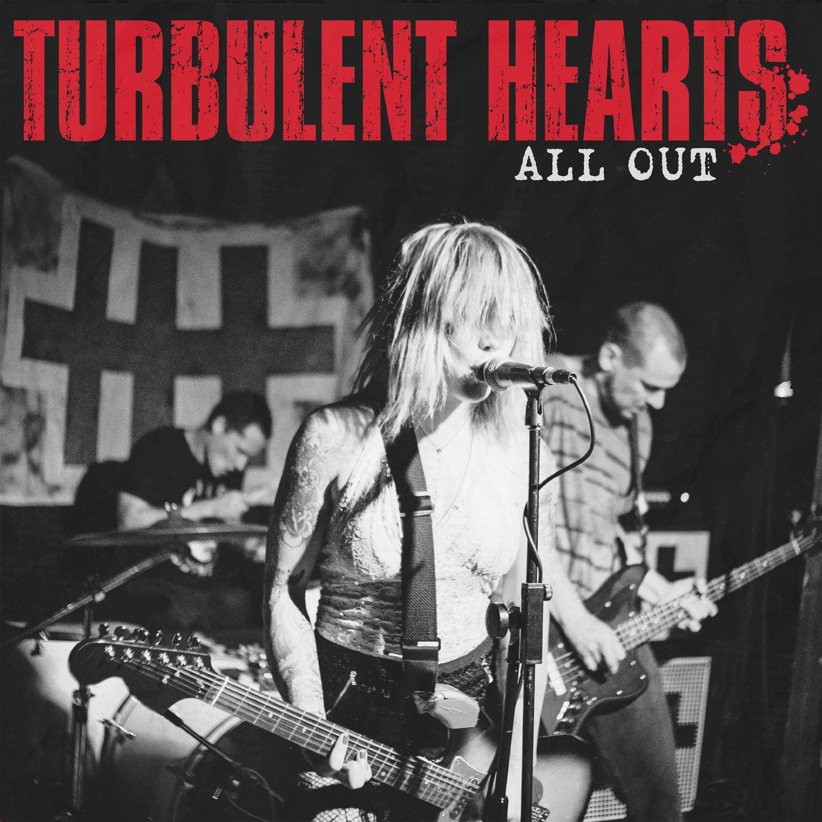Black and white image of Turbulent Hearts live with Suzi Moon at the front. "TURBULENT HEARTS: ALL OUT" in bold red crowns the scene, as a banner with symbols highlights their dynamic double LP from Suzi Moon.