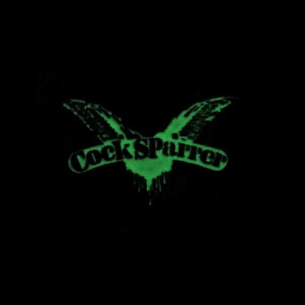Cock Sparrer glow-in-the-dark enamel pin featuring their green logo with wings and stylized text on a black background—perfect for fans.