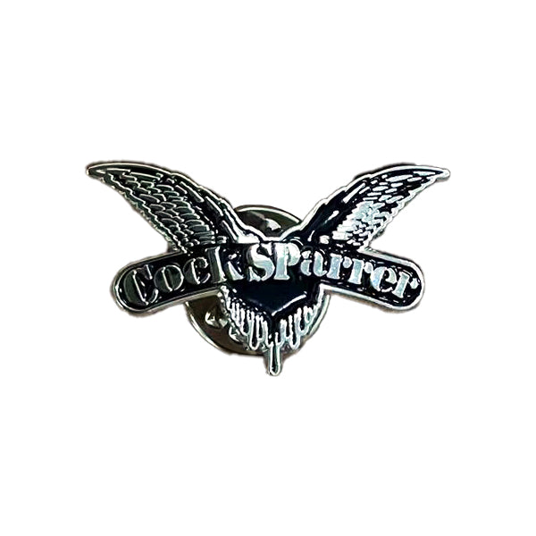 A Cock Sparrer enamel pin by Cock Sparrer, showcasing an outstretched bird with “Cock Sparrer” text on its wings, set on a white background and fastened with a military-style clutch.