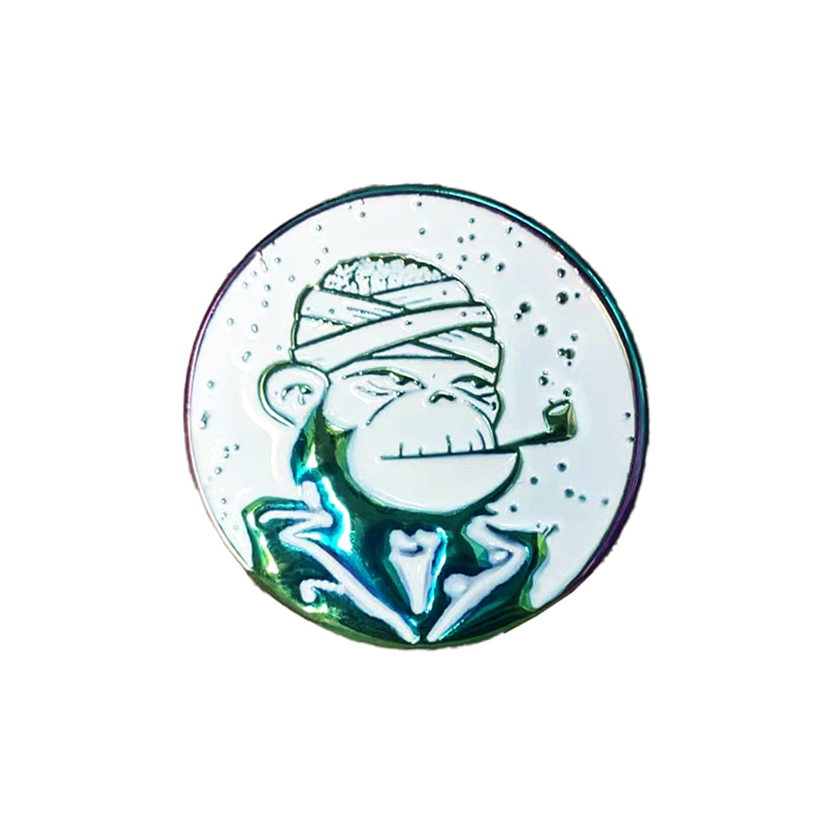 A round metal pin from DeeCracks features a stylized cartoon monkey with a bandaged head, jacket, and cigar. The Ape logo shines with an iridescent finish that stands out against the white background.