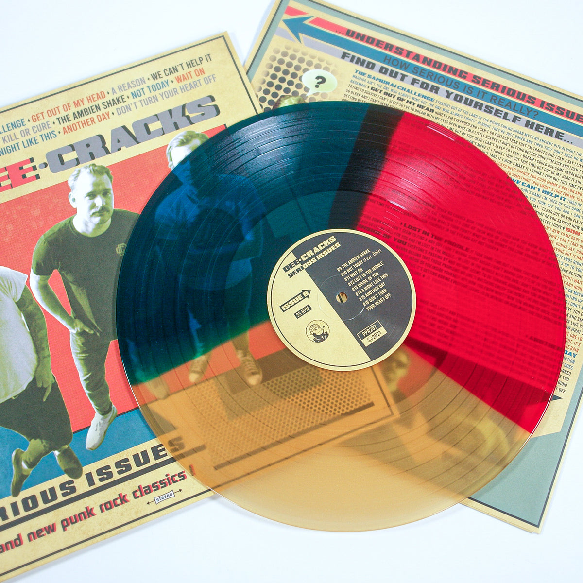 A DeeCracks vinyl record with transparent blue, red, and tan sections rests on its album cover, which displays three men and bold vintage graphics inspired by the Austrian rock 'n' roll scene.