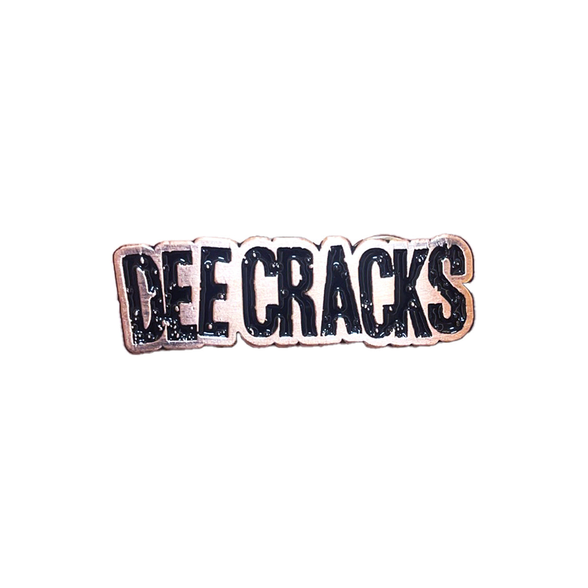 A DeeCracks enamel pin with bold black uppercase letters outlined in white spelling &quot;DEE CRACKS&quot; on a white background, secured with a military-style metal clutch.