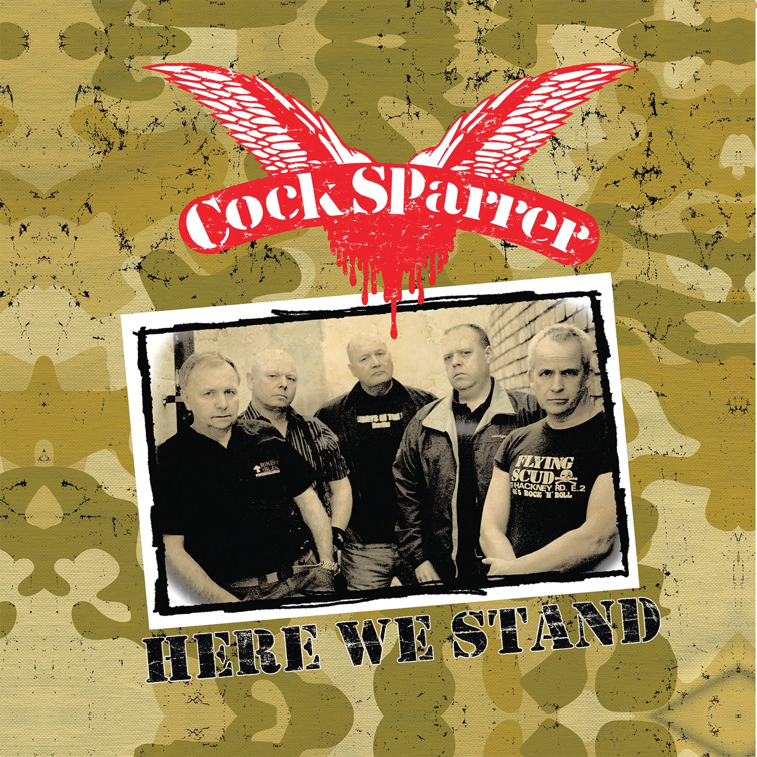 Album cover with Cock Sparrer, punk rock legends, in a black-and-white photo under their red winged logo and the album title “Here We Stand,” all set against a camouflage background. Brand: Cock Sparrer.