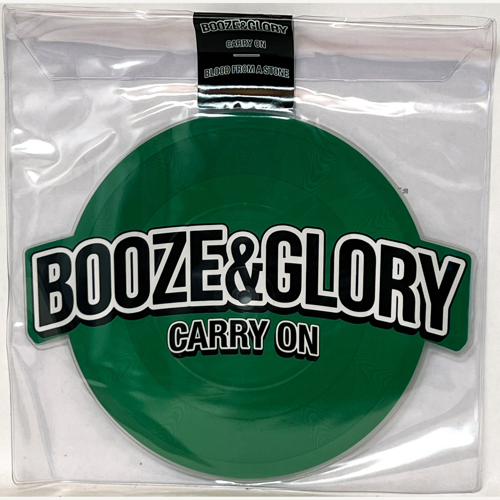 A green Booze & Glory Carry On vinyl in a clear plastic sleeve with bold front lettering. This limited edition features Carry On and Blood From a Stone, both listed on the top label.
