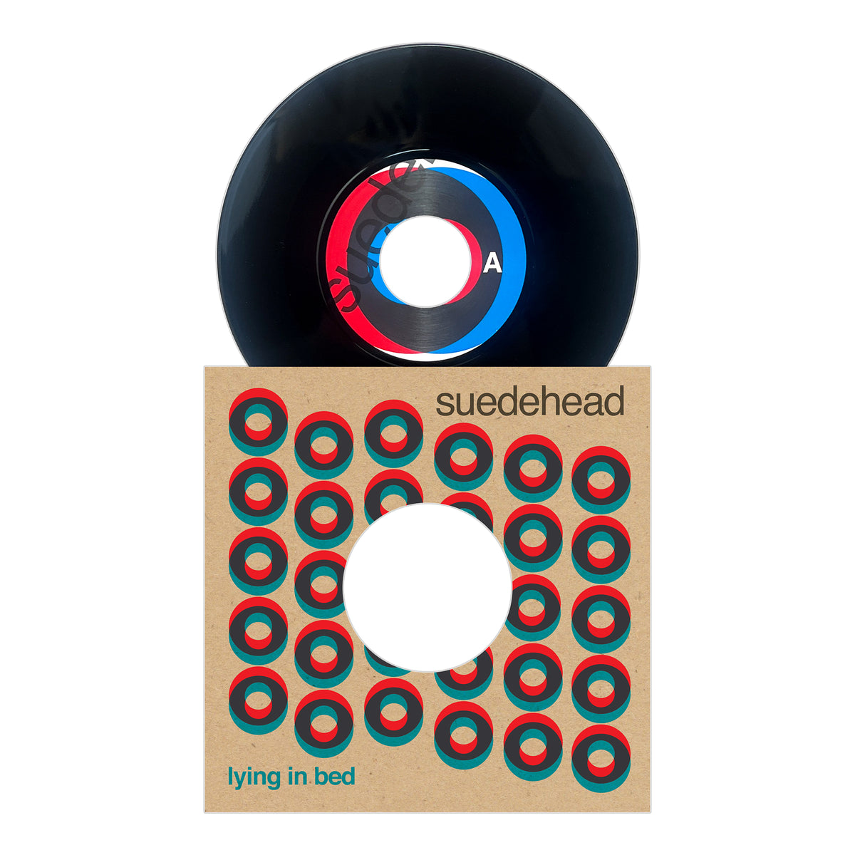 A black vinyl record labeled Side A is partially inserted into a sleeve decorated with a pattern of red and green circles and printed with the text "Suedehead" and "Lying in Bed," reflecting the energetic aesthetic commonly linked to Suedehead's discography and their roots in Northern Soul punk culture.