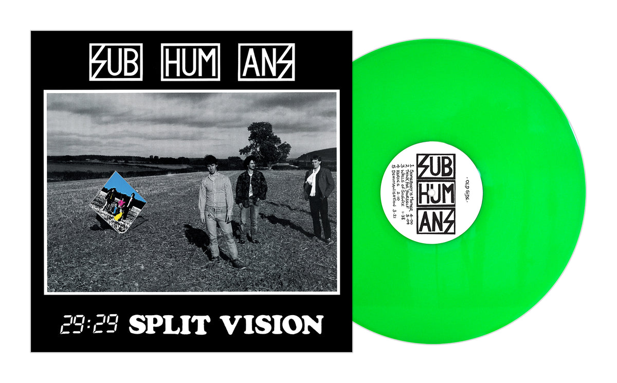 A neon green vinyl record sits next to the album cover for Subhumans 29:29 Split Vision, featuring a black-and-white band photo in a barren field beneath a cloudy sky.