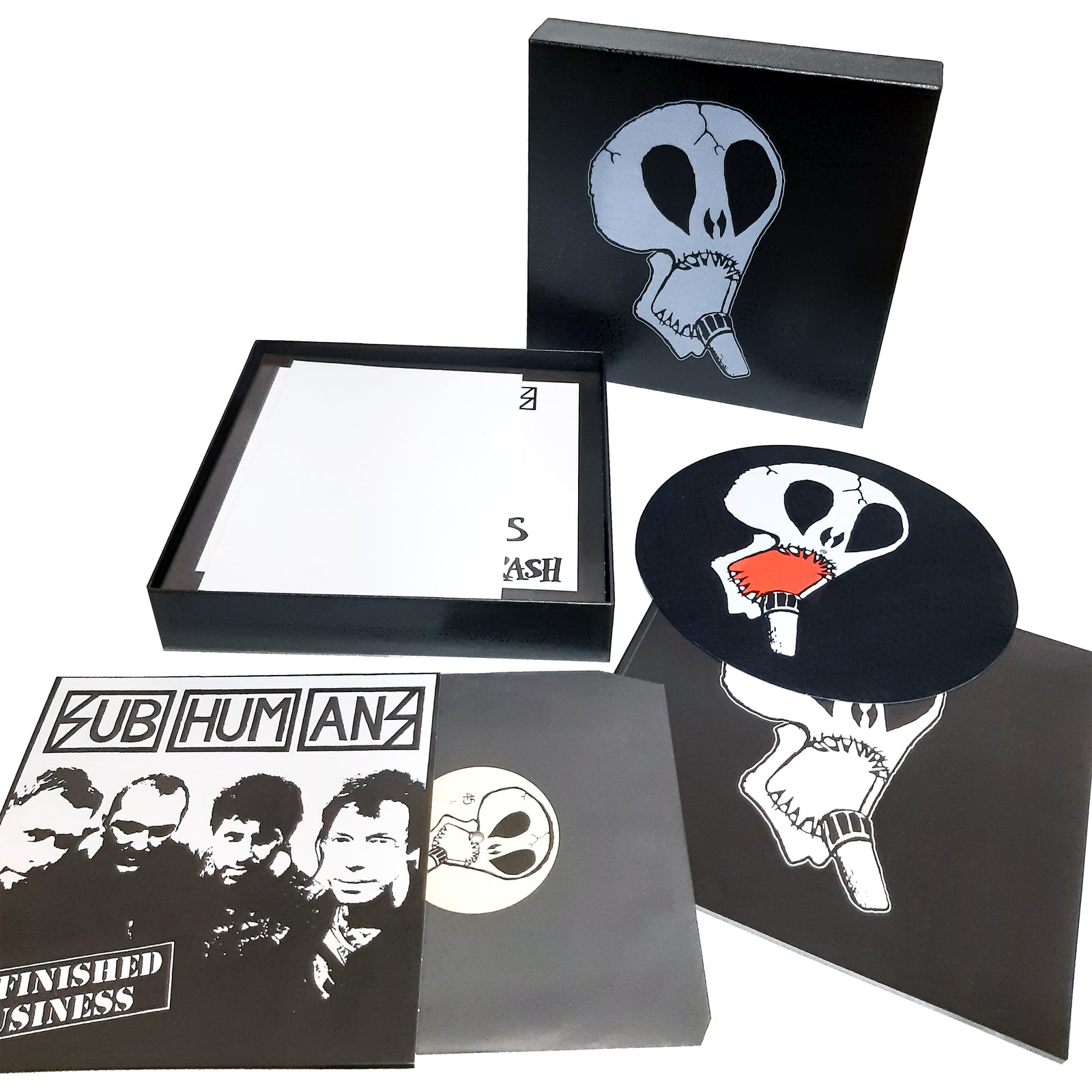 Subhumans box set with black skull design, includes vinyl records, booklet, round slipmat matching the skull image, plus the Unfinished Business album cover in black and white featuring the anarcho punk band members’ faces. Brand: Subhumans.