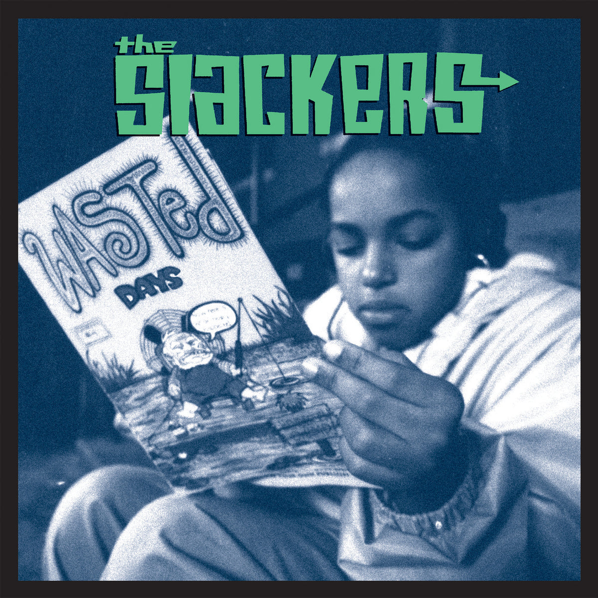 A young person reads a comic book titled Wasted Days while sitting indoors. The image is tinted blue, with The Slackers—the brand name—in bold green letters at the top, inspired by the iconic ska album cover.