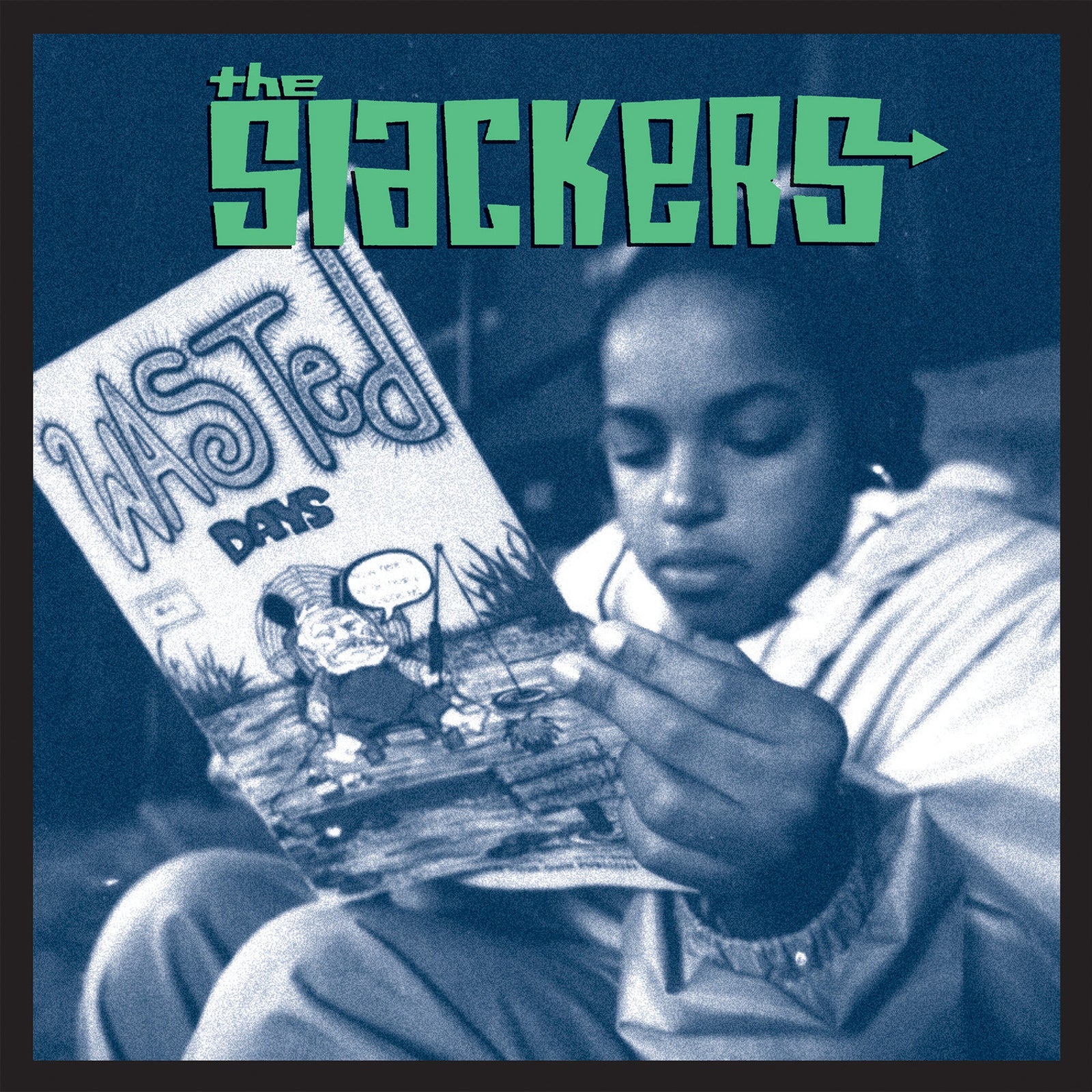 A person in a light jacket reads The Slackers ska album comic Wasted Days, which features a blue-tinted cover with a cartoon fisherman and The Slackers brand name in stylized text at the top.