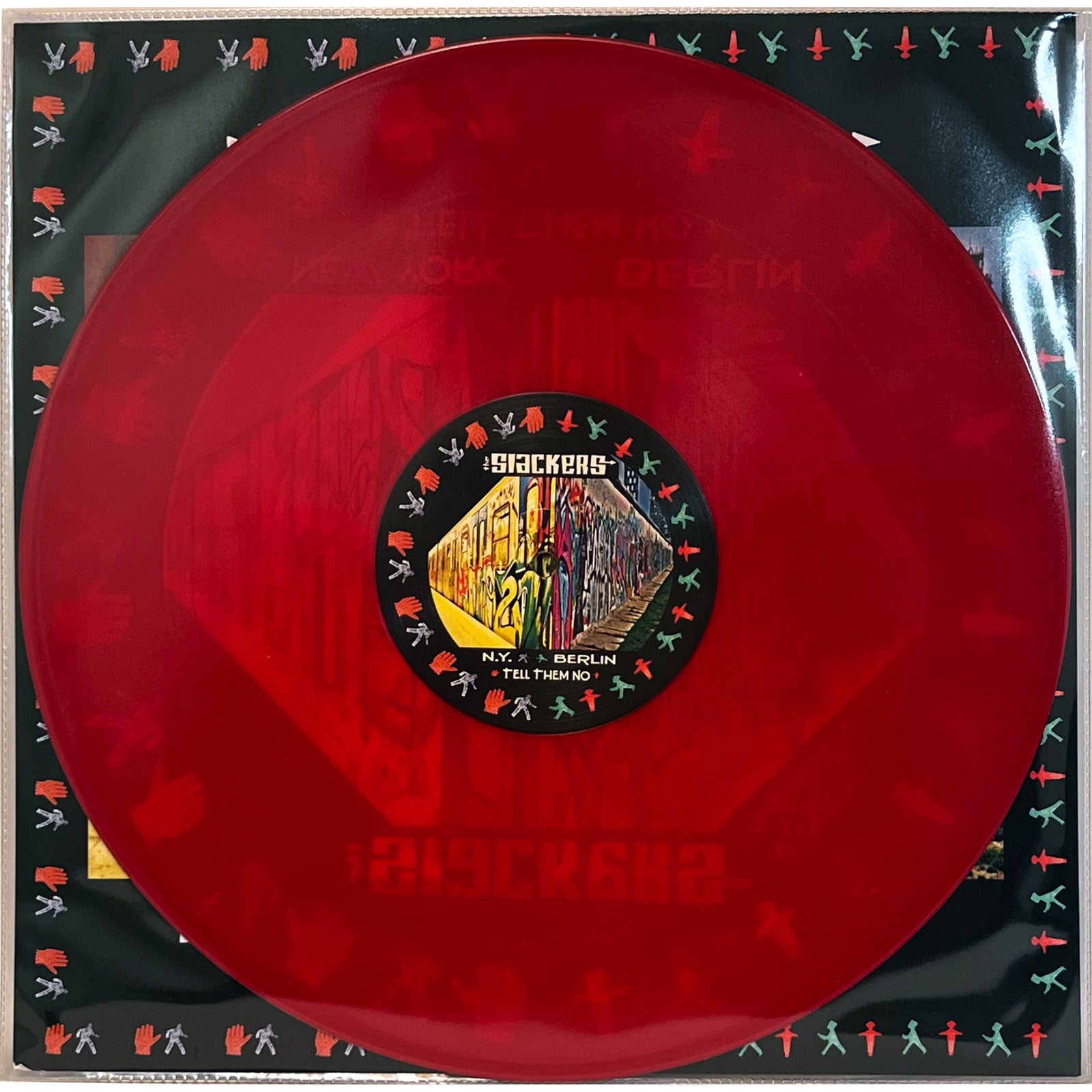 A translucent red vinyl of The Slackers NYC → BERLIN rests on a square sleeve with colorful outlined figures and a multicolored center label—the perfect standout for any NYC reggae collection.