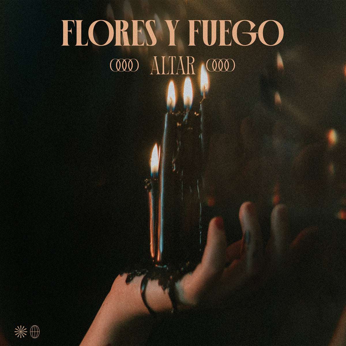 A hand grips four black, burning candles as wax drips down the fingers against a dark background. “Flores Y Fuego Altar” glows above, honoring Guadalajara’s hardcore punk band and their raw energy. Brand: Flores Y Fuego.