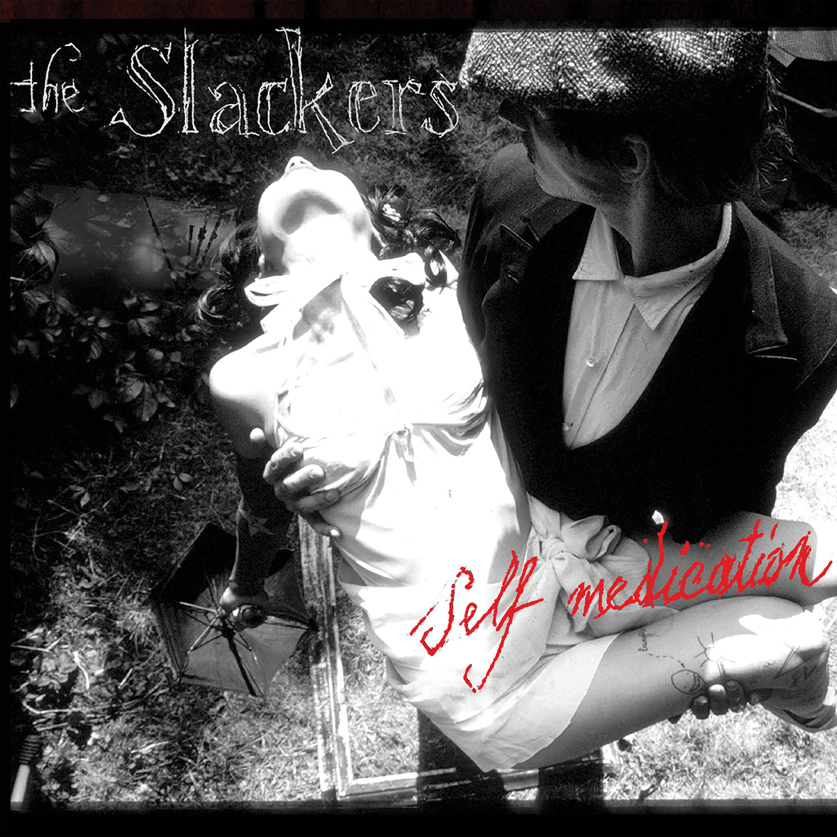 Black and white cover for The Slackers&#39; Self Medication LP: a suited man in a hat holds an unconscious woman in a white dress. The ska reggae album title appears in red script. Brand: The Slackers.