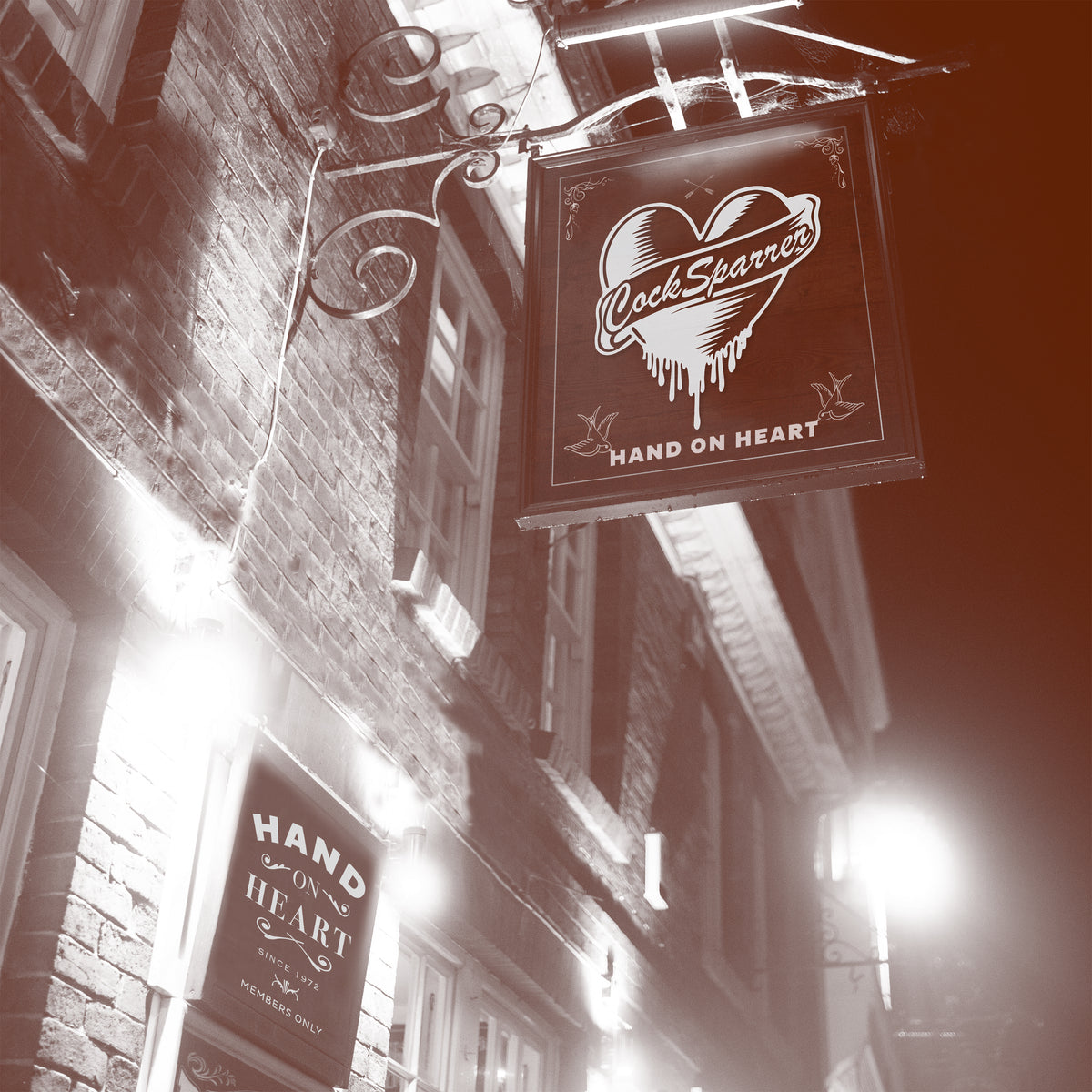 Sepia-toned photo of a brick building at night with a hanging sign featuring a heart and &quot;Cock Sparrer - HAND ON HEART,&quot; plus another sign below reading &quot;Hand On Heart - Members Only,&quot; capturing Cock Sparrer’s punk rock album vibe in bright lights.