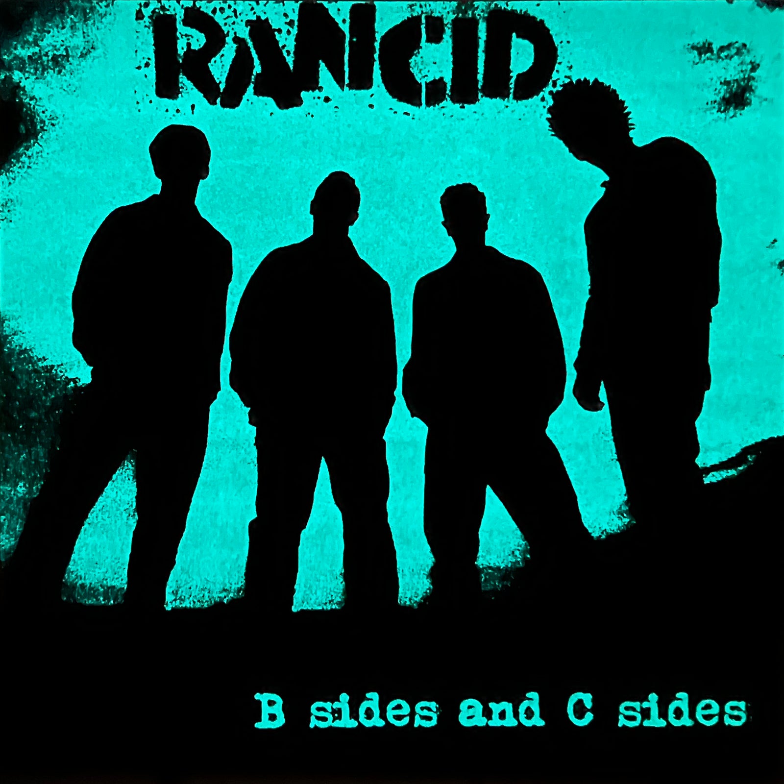 Four silhouettes stand against a blue-green background, with Rancid’s name at the top and “B Sides and C Sides” at the bottom, spotlighting their Epitaph Records era.