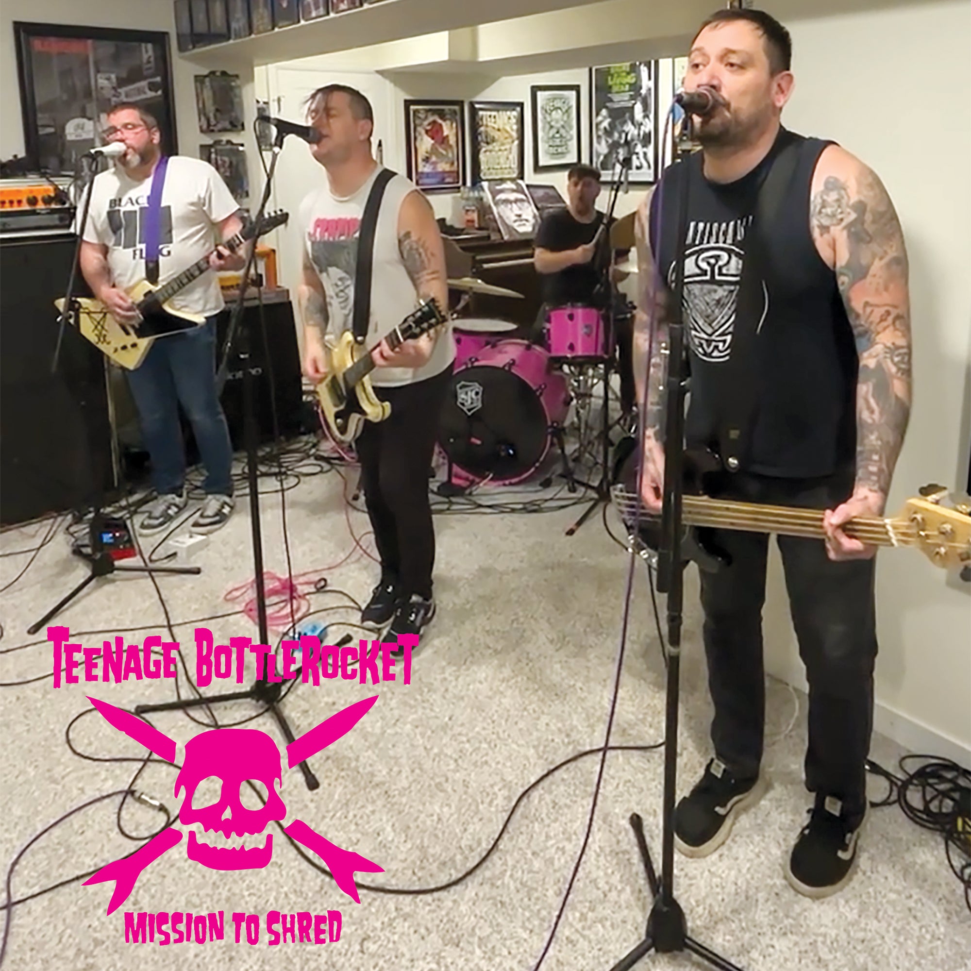Four tattooed musicians perform among music gear and framed art—two on guitar, one singing and playing bass, one on drums. The Teenage Bottlerocket brand name and “Mission To Shred Sessions” appear in pink.