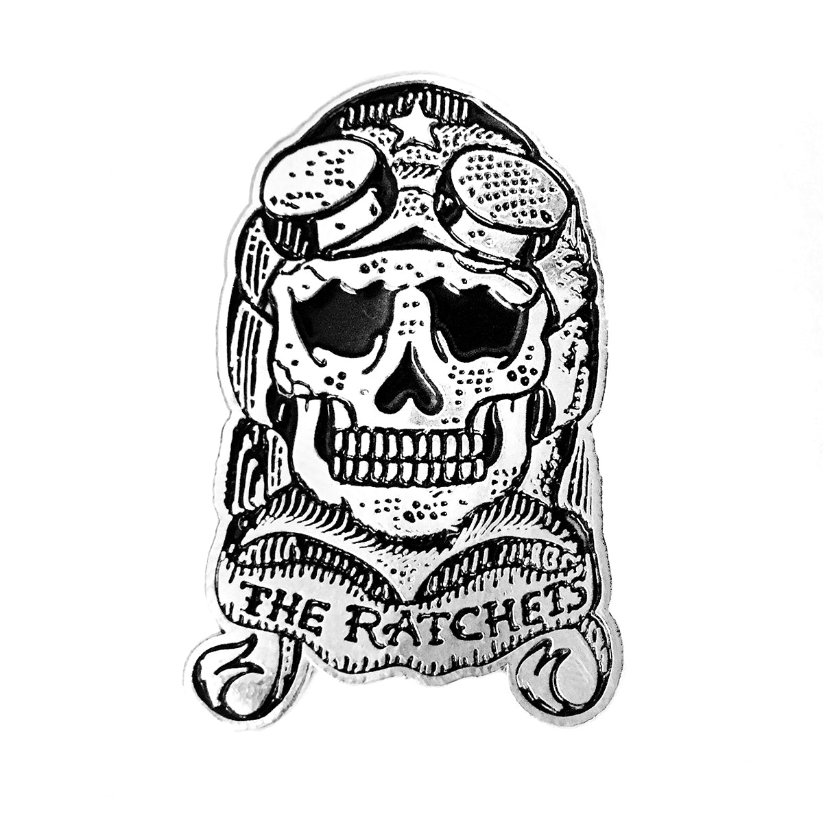 A bold 1.5&quot; enamel pin from Ratchets features a black and white skull with goggles and helmet, plus a banner reading THE RATCHETS—perfect for fans wanting the ultimate Skull Logo accessory.