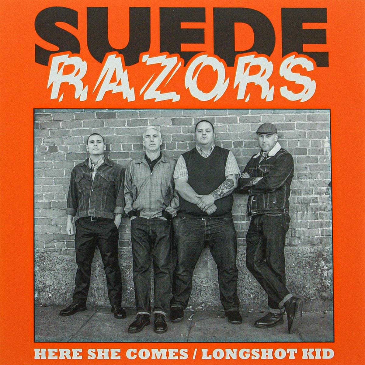 Album cover features Suede Razors, the San Francisco punk band, with four men in front of a brick wall. “Suede Razors” is boldly above and “Here She Comes / Longshot Kid” below on an orange background with retro rock 'n' roll style.