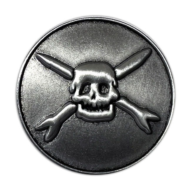 A round silver coin from Teenage Bottlerocket features a raised skull and crossed bones in the center, inspired by their Ready To Roll theme, set against a plain background.