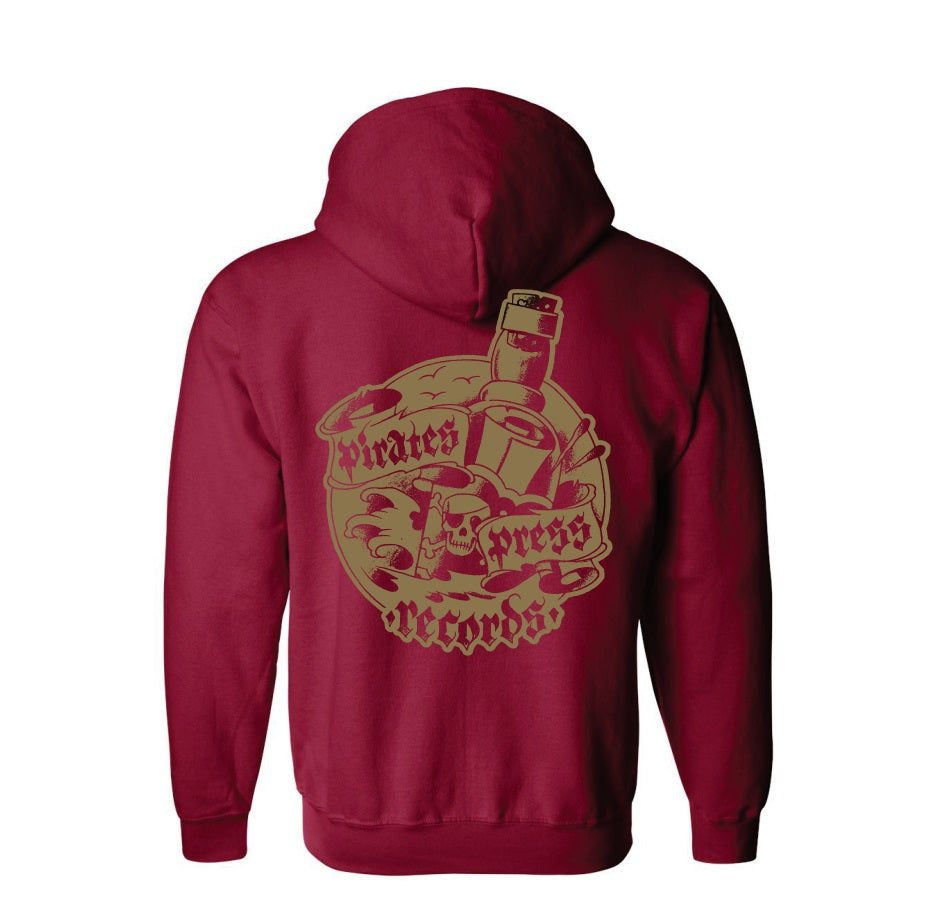 A maroon zip-up hoodie by Pirates Press Records with a large gold back graphic featuring a skull, microphone, spray can, vinyl record, and bold brand text.