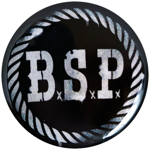 A 1&quot; round black pin by The Bar Stool Preachers featuring a white rope border, distressed BSP stencil letters in the center, and small x symbols beneath each letter—a must-have for any fan.