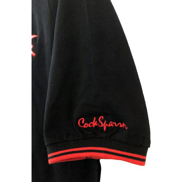 A classic black Cock Sparrer short-sleeve shirt with red trim at the cuff and an embroidered red Cock Sparrer crest near the sleeve hem.
