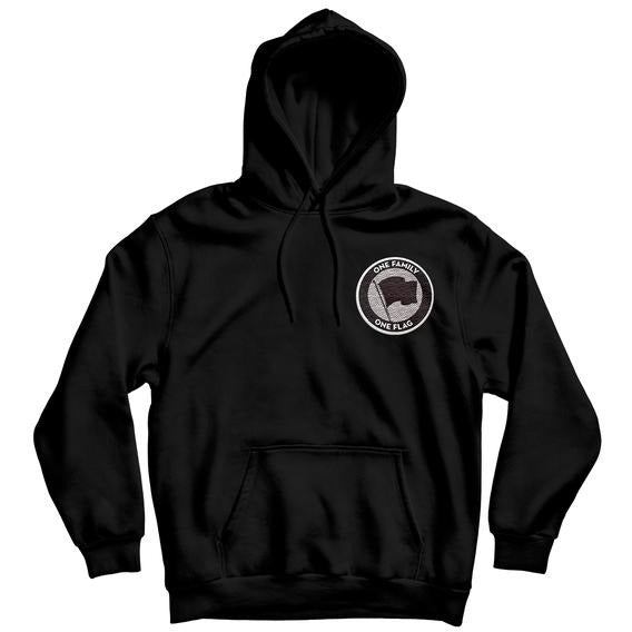 Black pullover hoodie by Pirates Press Records featuring an embroidered patch of a circular logo with a flag icon in the center and “ONE FAMILY, ONE FLAG” around the border on the left chest.