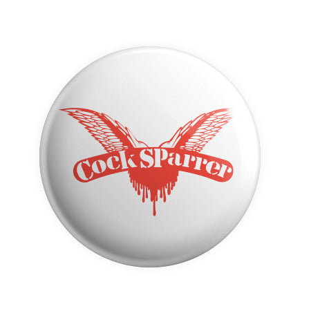 A Cock Sparrer button badge with a white background features a red winged heart and “Cock Sparrer” text across the wings, plus red drips below that look like blood—a must-have for fans of the band.