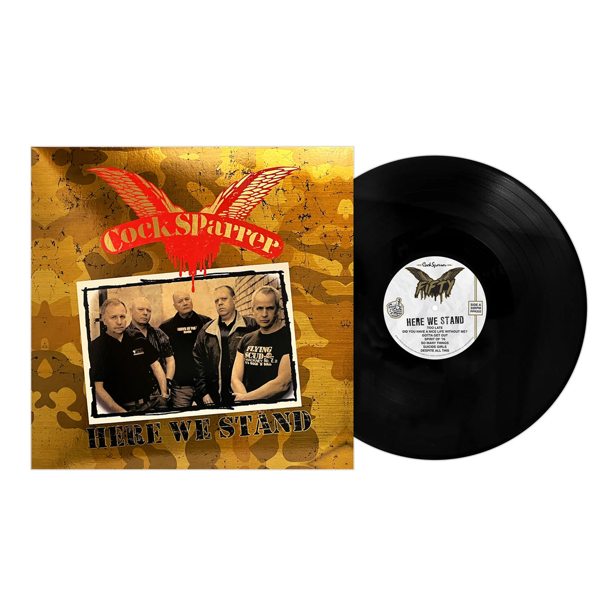 Vinyl record beside its cover, showing Cock Sparrer beneath a red winged logo and the title “Here We Stand” on a gold camouflage background. Brand: Cock Sparrer.