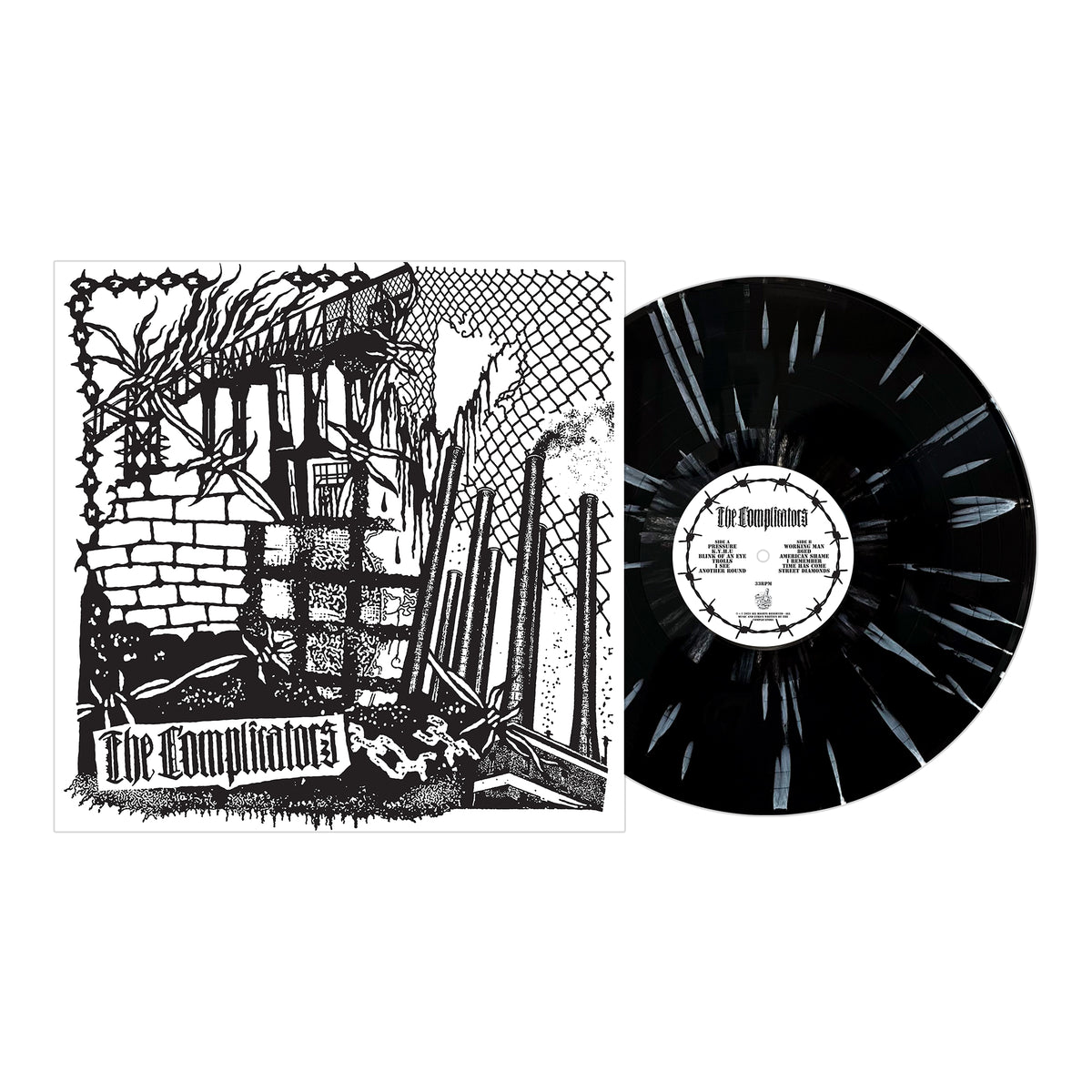 A black vinyl record with white splatter sits by its black-and-white album cover, featuring barbed wire, a crumbling wall, and “The Complicators” in gothic font—a true tribute to working class punk and British Oi roots.