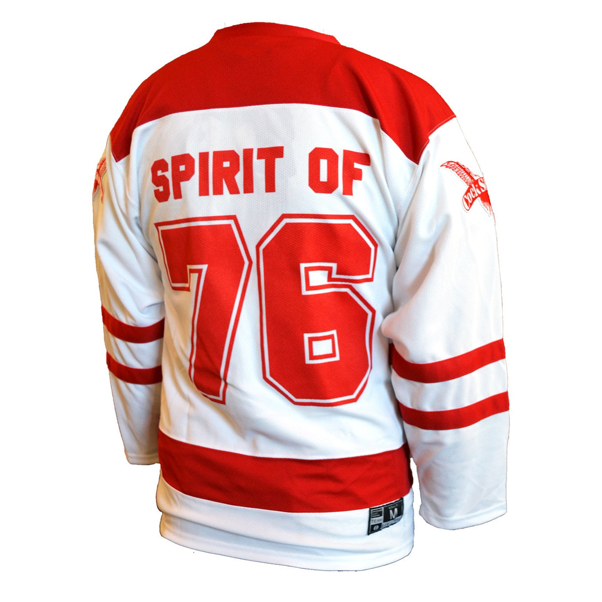 A Cock Sparrer white hockey jersey with red accents features “SPIRIT OF” above a large 76 on the back, red stripes on sleeves and lower torso, and embroidered wing patches for detail.
